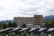 秦野病院外観。後ろには丹沢の山々が見えます。