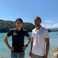 共同代表の早川（左）と岩本（右）／本店漁場・那佐湾を背景に。総合商社営業マンと理学博士という異色のコラボ。