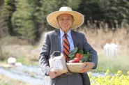 当社で作ったお米と野菜を抱える代表 遠藤
