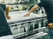 タオル織機と連なる糸を操り、職人の技工によってタオルを織り出します。