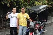 フィリピン現地法人の社員と当社サービスを利用するトライシクルドライバー