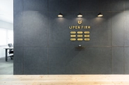 H A T C Hが運営するシェアオフィス「OPEN FIRM」中目黒オフィスのエントランス。シェアオフィスに入居する会社のプレートが貼ってあります。