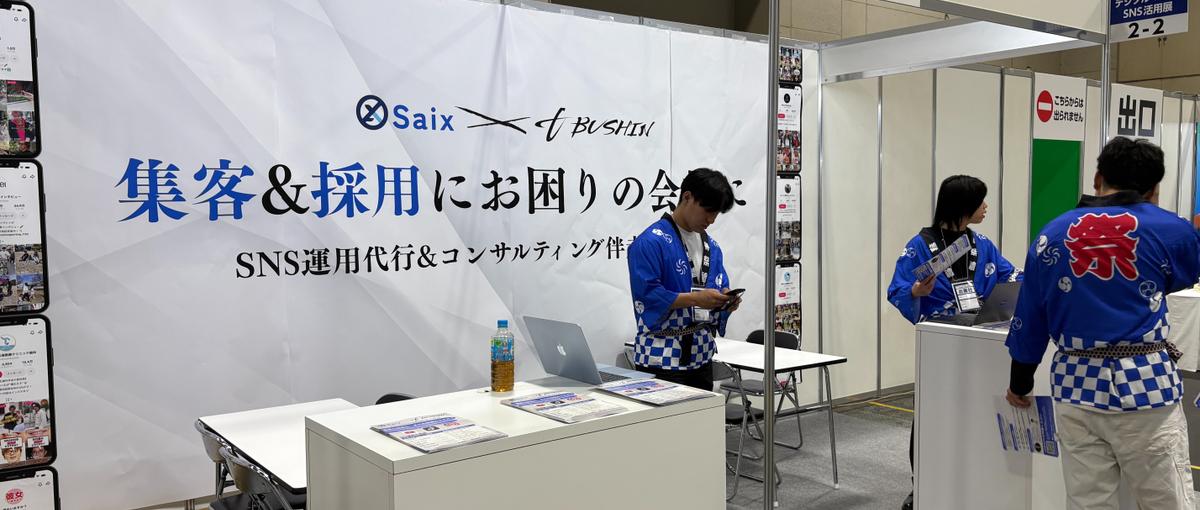 福岡のAI展示会ブースで、来場した経営者に声をかける営業スタッフ