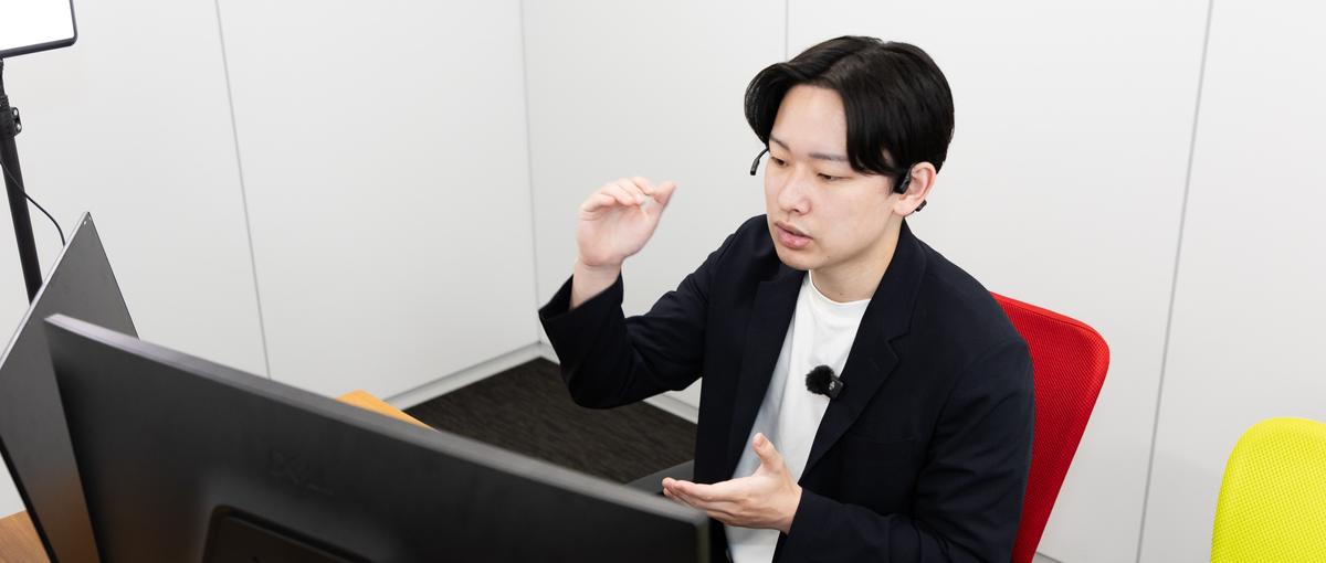 AI展示会のブースで、来場した経営者に声をかける営業スタッフ
